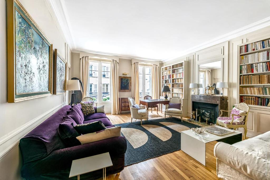 a living room with a purple couch and a fireplace at Gros Caillou - Grenelle 2bdr in Paris