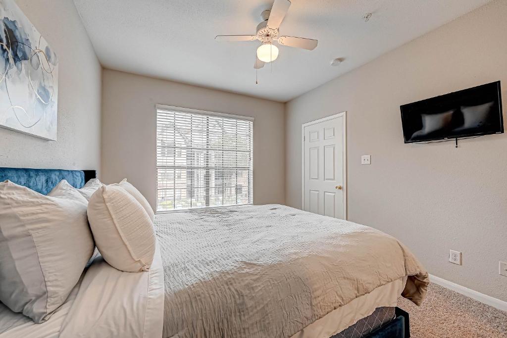Schlafzimmer mit einem Bett und einem Deckenventilator in der Unterkunft Houston's City Center Apartment in Houston