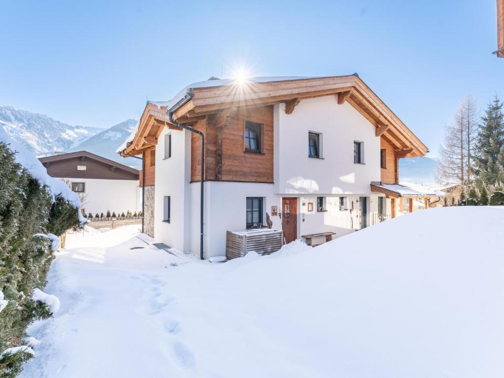 dom ze śniegiem przed nim w obiekcie Green Garden Lodge B1 w mieście Piesendorf