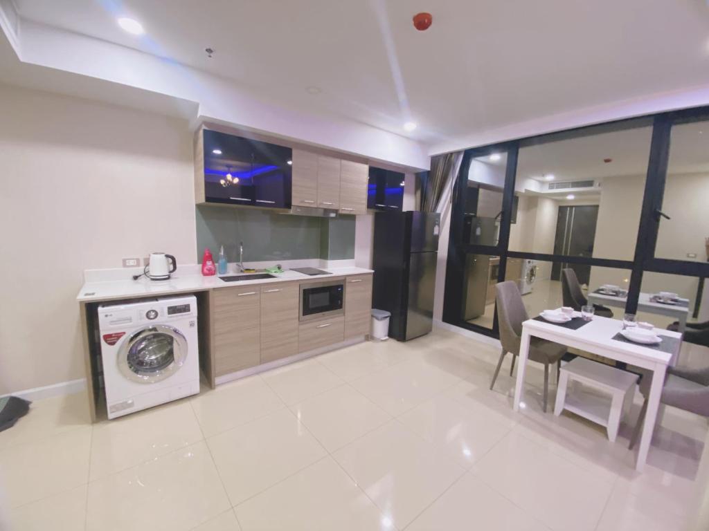 a kitchen with a washing machine and a table at dusit grand condo view高层海景房 in Jomtien Beach