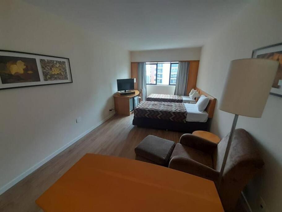 a living room with a bed and a couch at Sol Alphaville Flat Equipado lazer e trabalho in Barueri