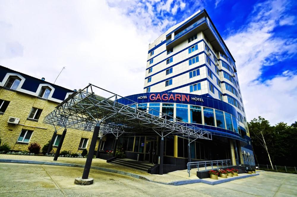 a large building with a sign on the front of it at Gagarin Hotel in Yuzhno-Sakhalinsk