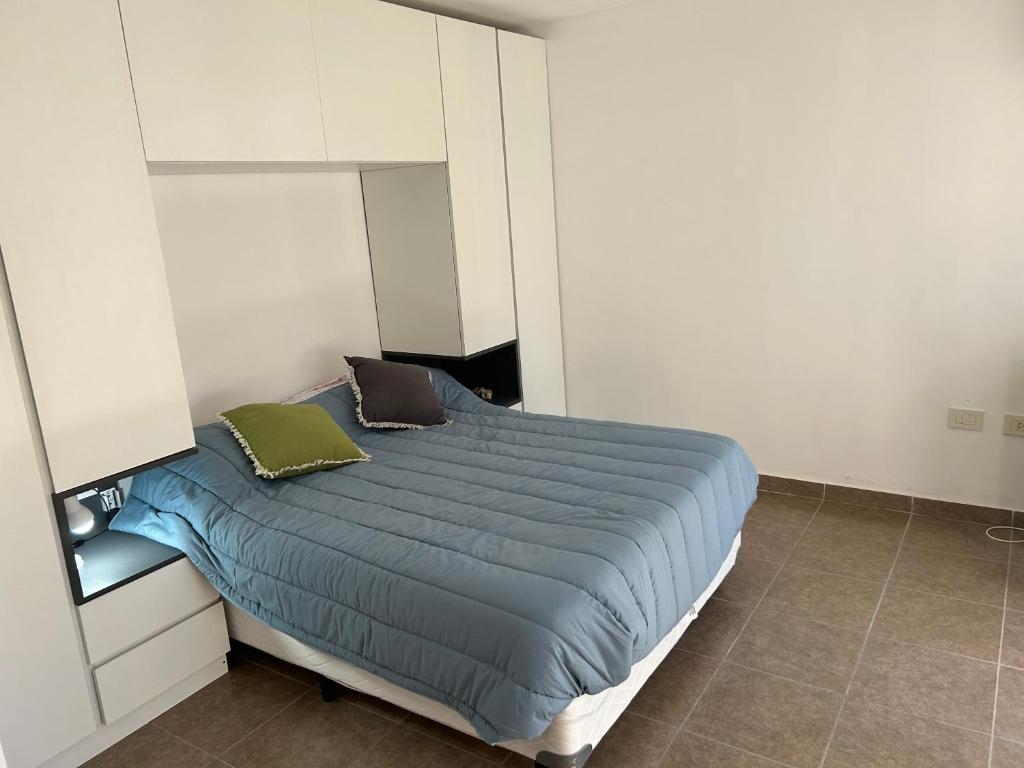 1 dormitorio con 1 cama con edredón azul en Cálido MonoAmbiente SinCochera en Rosario