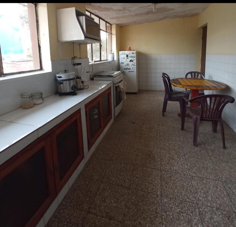 洛維托斯區的住宿－Casa hospedaje cora，厨房配有桌子和桌椅