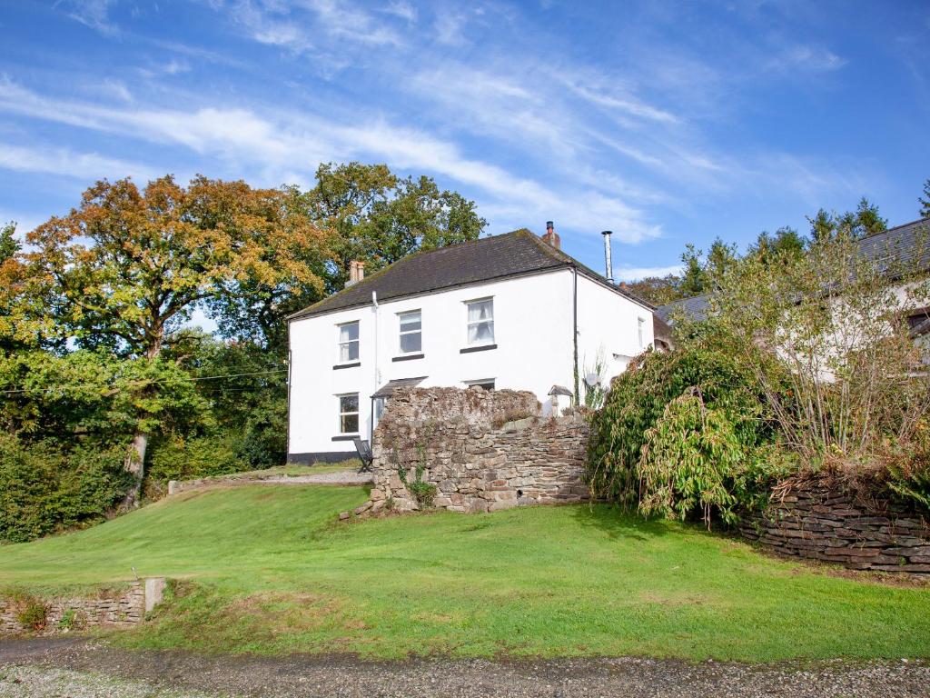 a white house on top of a stone wall at Uk45542-the Farm House in Sticklepath