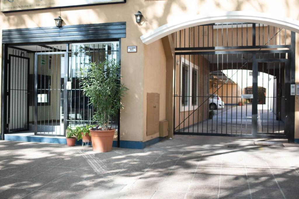 dois portões para um edifício com plantas neles em Hostel Los Andes em Guaymallén