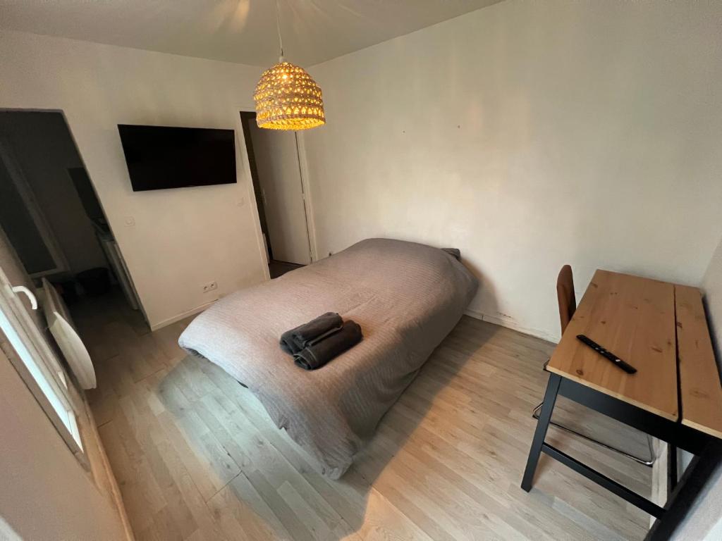 a room with a bed and a table with a bag on it at Studio proche La Defense in Puteaux