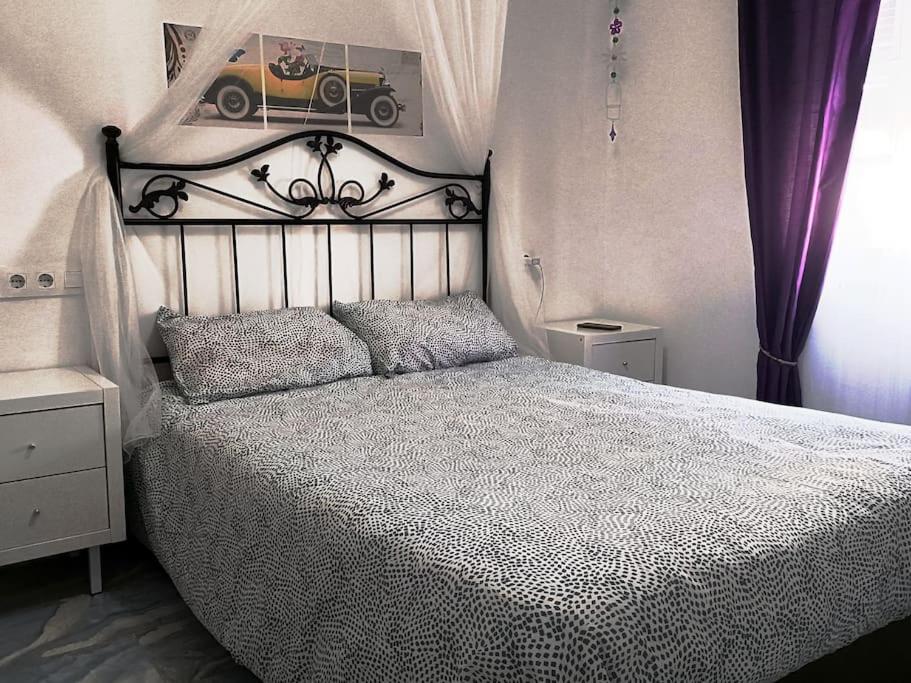 een slaapkamer met een bed met een zwart-wit dekbed bij casa familiar in San Fernando