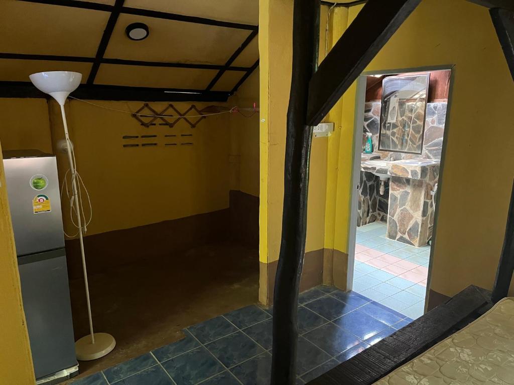 un couloir avec une chambre aux murs jaunes et une lampe dans l'établissement Silver cliff room 15, à Than Sadet Beach