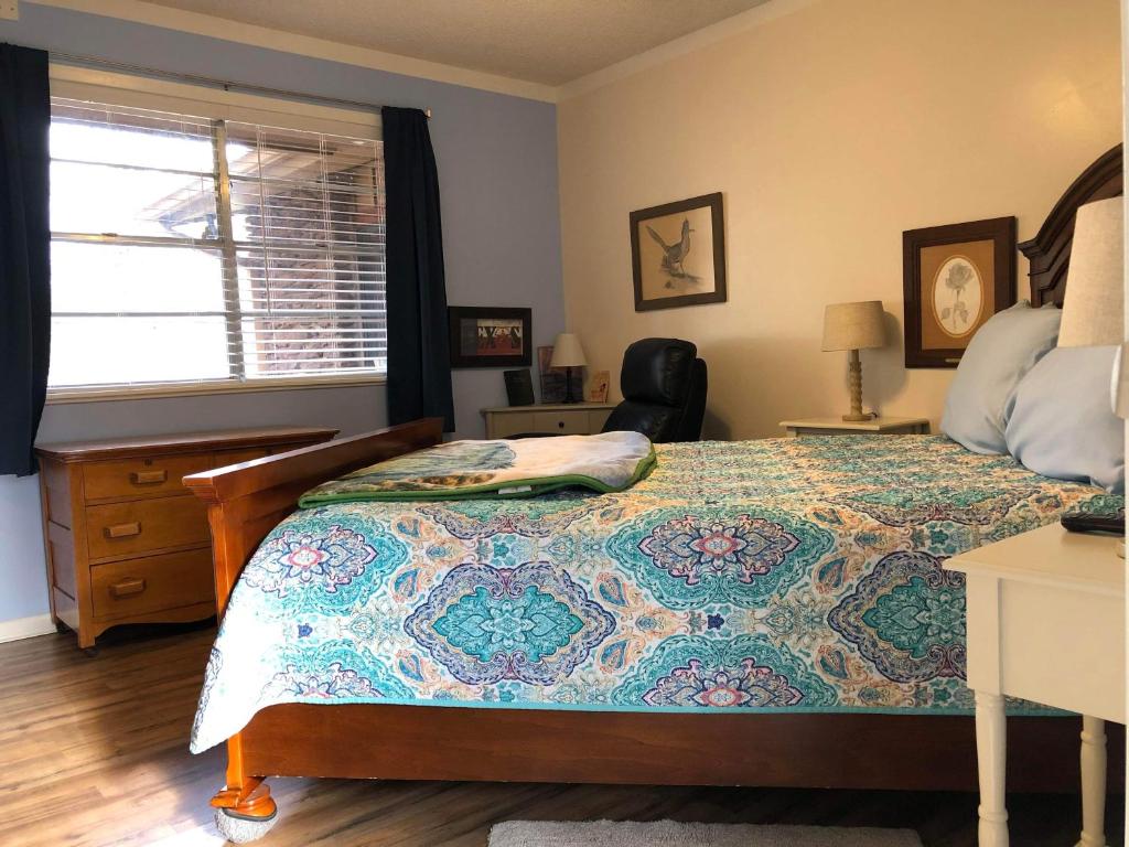 a bedroom with a bed and a desk and a window at Fishers Of Men Ranch Home in Marble Falls