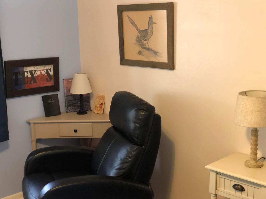 a living room with a black chair and a desk at Fishers Of Men Ranch Home in Marble Falls