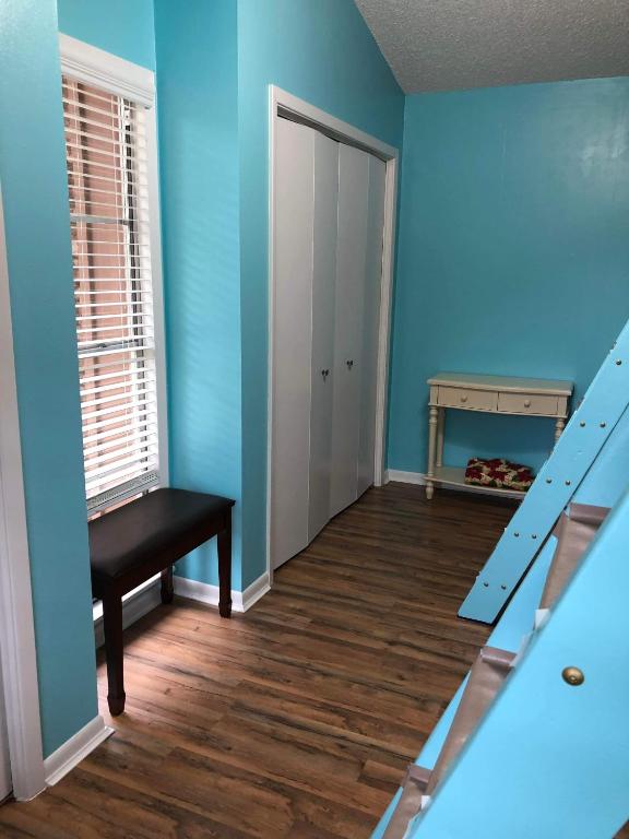 a room with blue walls and a door and a bench at Fishers Of Men Ranch Home in Marble Falls