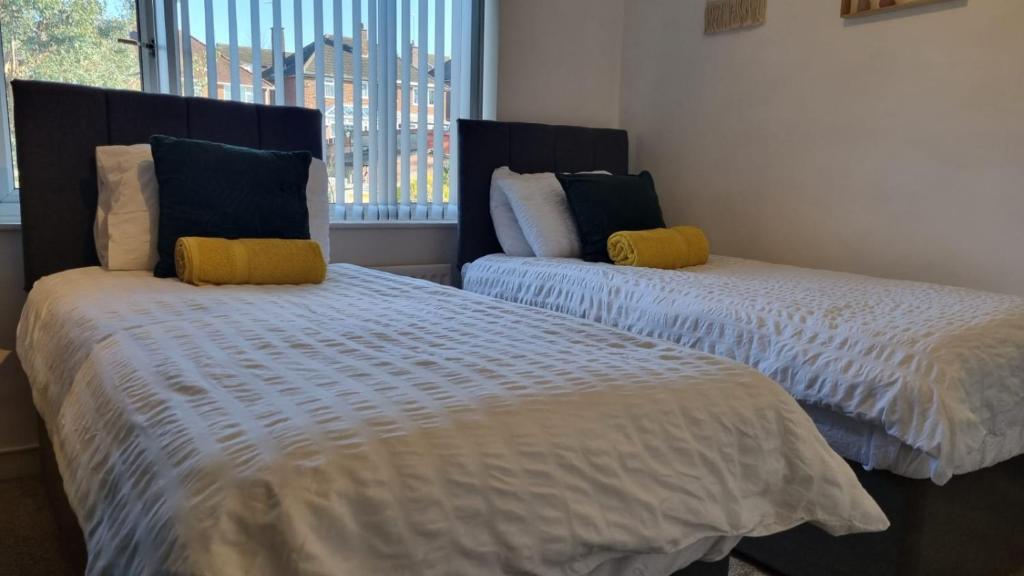 a bedroom with two beds and a window at B43 Cosy Home - Contractor-Family Stays Near Bhm City-Off Road Parking Free Wi-fi in Holly Lane