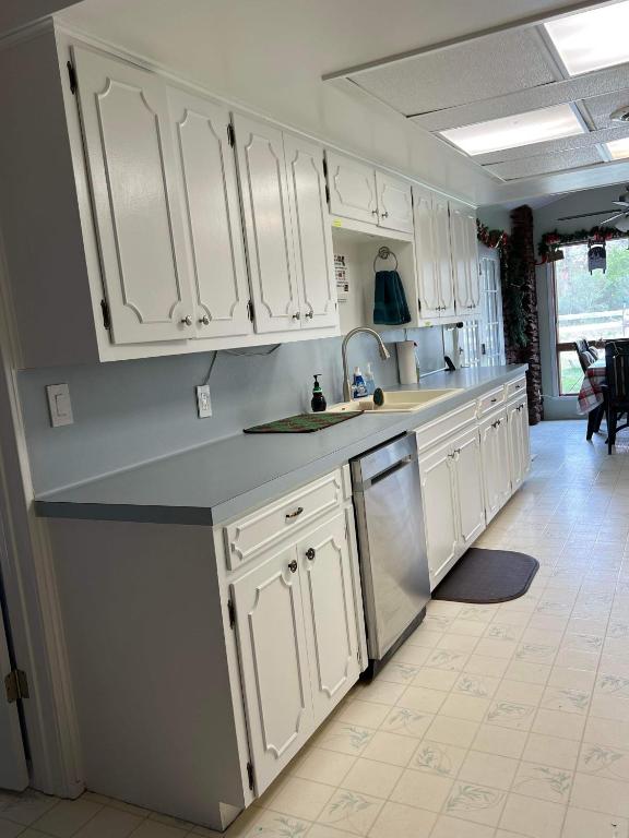 a kitchen with white cabinets and a sink at Fishers Of Men Ranch Home in Marble Falls