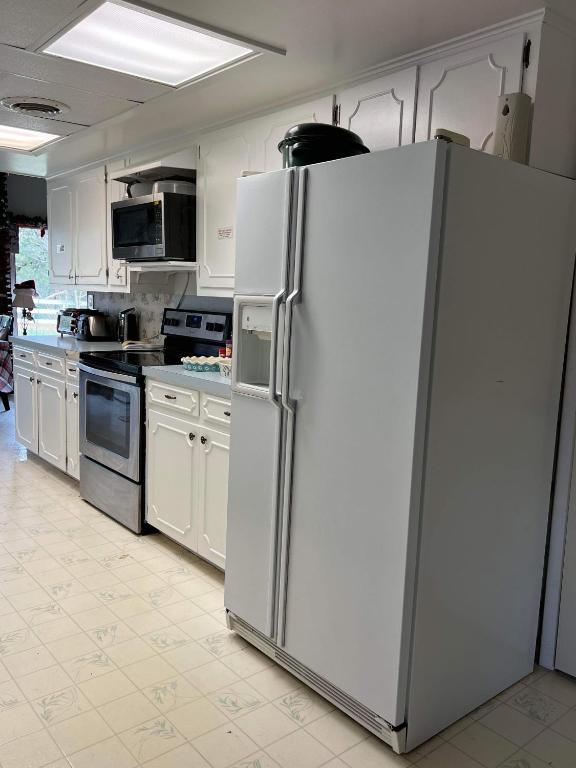 a kitchen with a large white refrigerator in it at Fishers Of Men Ranch Home in Marble Falls