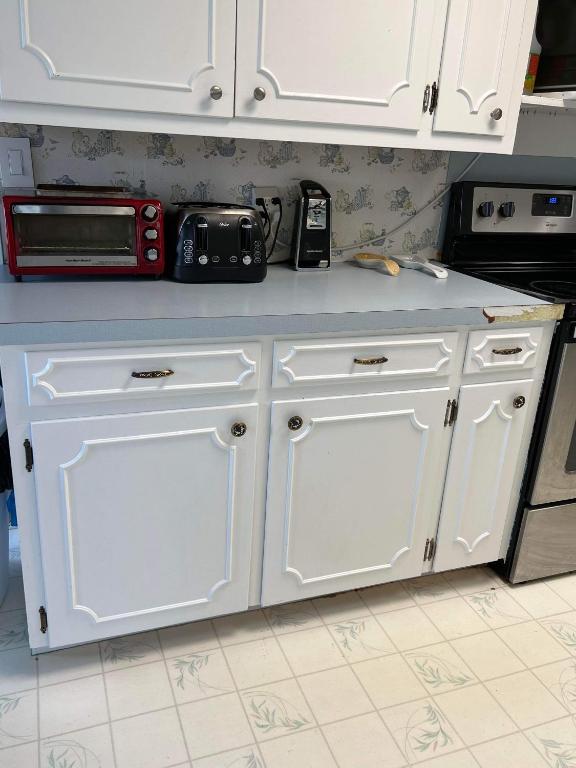 a kitchen counter with white cabinets and a microwave at Fishers Of Men Ranch Home in Marble Falls