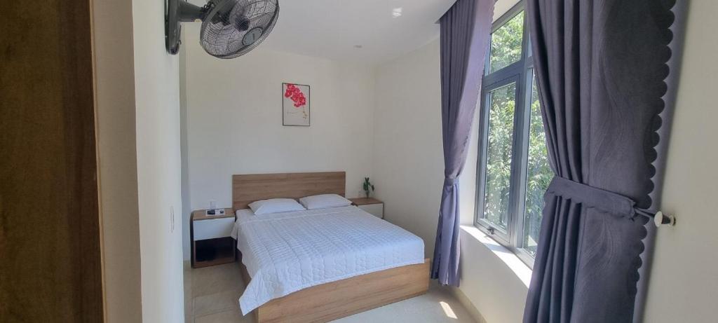 a small bedroom with a bed and a window at Sunn Hotel in Vung Tau
