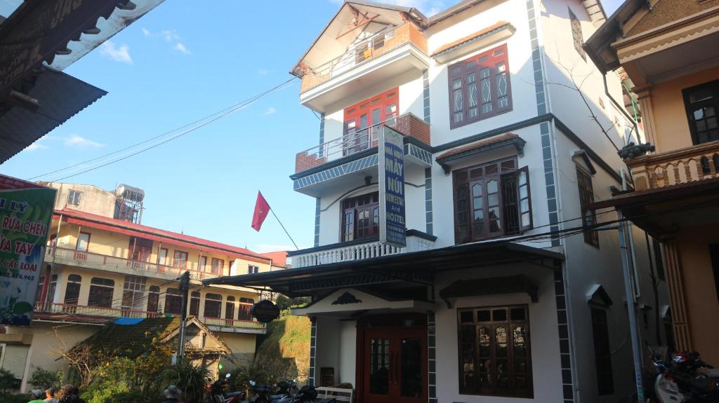 een wit gebouw met een balkon in een straat bij May Nui Sa Pa Hostel in Sa Pa