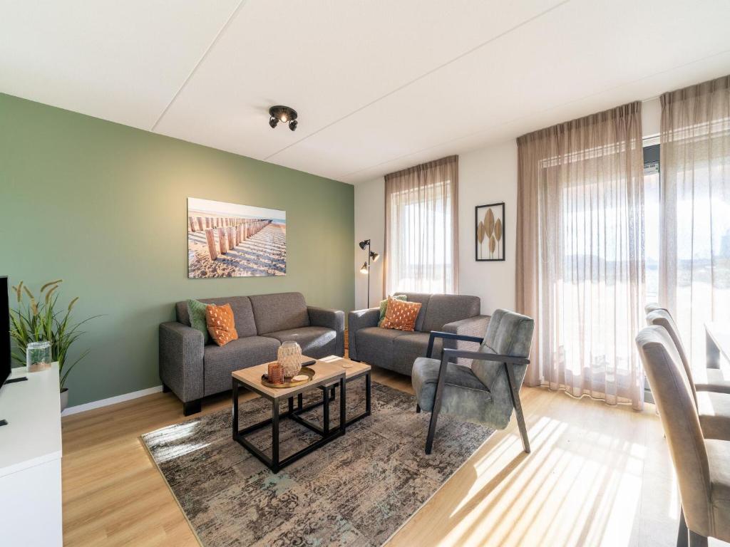 a living room with a couch and a table at Holiday Home in Scherpenisse near Nature Reserve in Westkerke