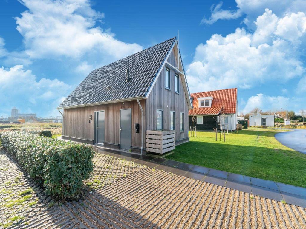 a barn style house with a gambrel roof at Nice holiday home in Scherpenisse with terrace 