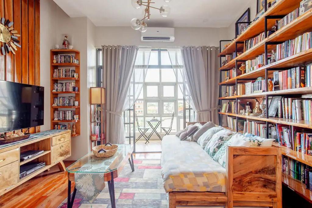 una sala de estar con sofá y estanterías de libros en Lovely Loft Apartment in Kalibo, Aklan, en Kalibo