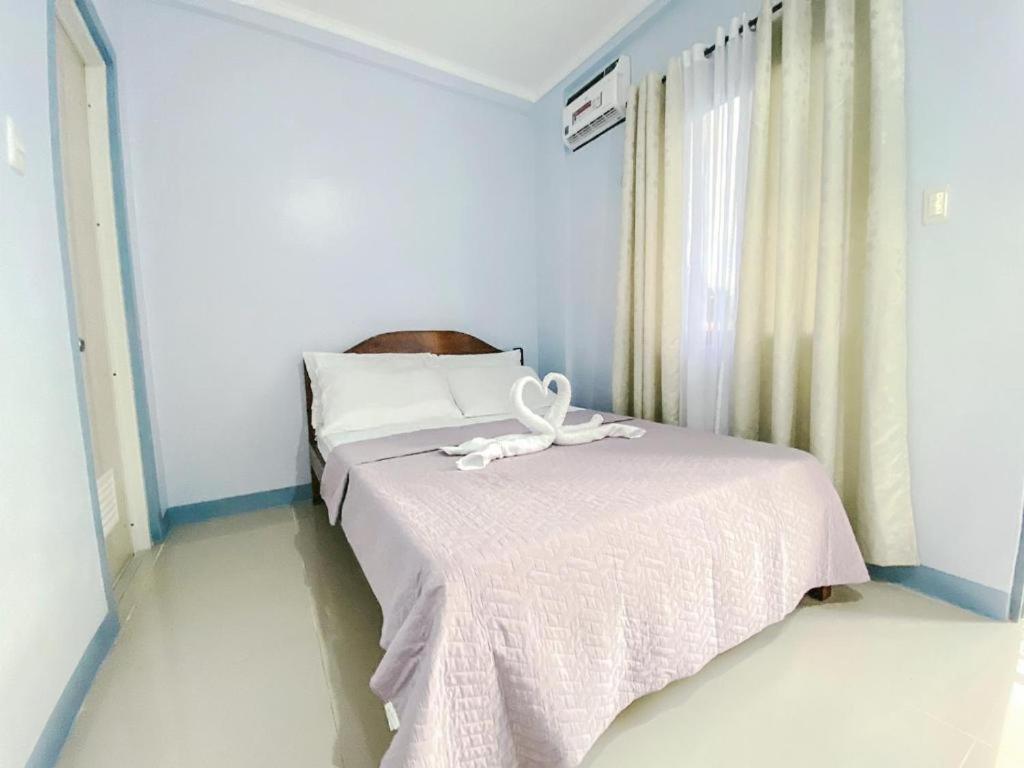 um quarto com uma cama com uma fita em Althea Apartelle em Moalboal