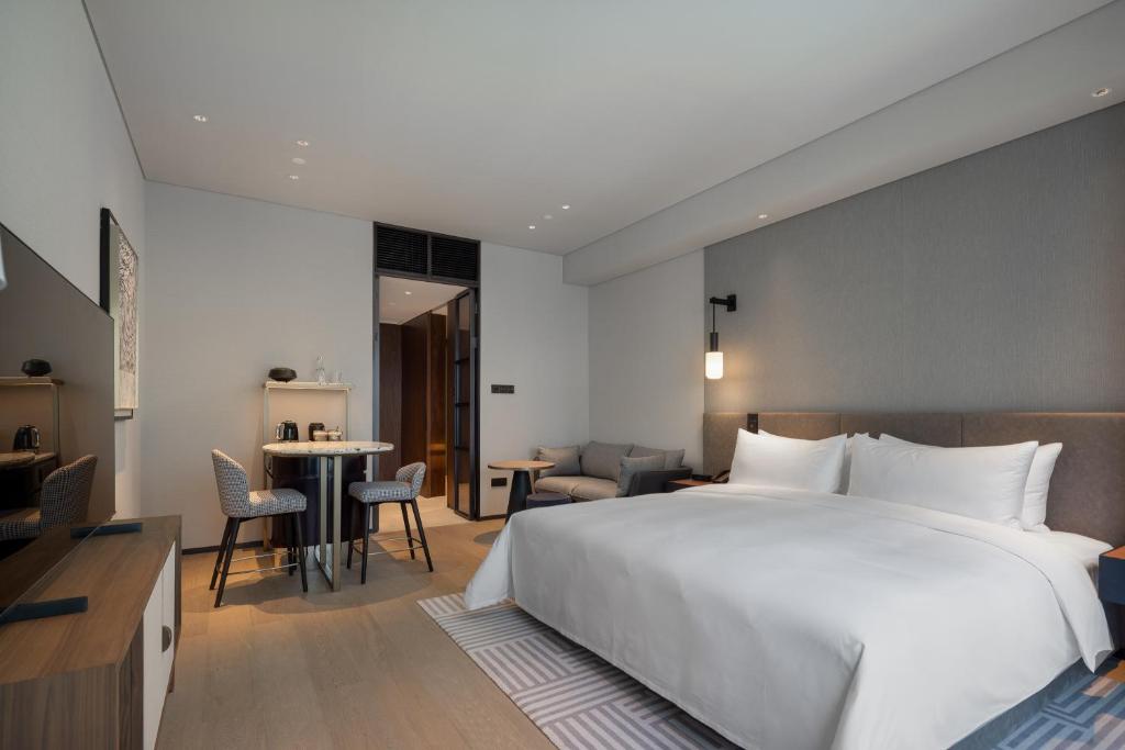 Postel nebo postele na pokoji v ubytování New World Guangzhou Hotel