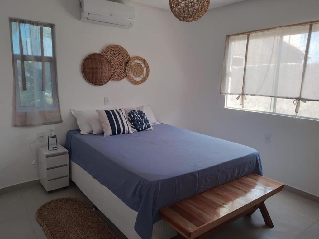 a bedroom with a bed and a bench in it at Vila do Mar - Macapá in Luis Correia