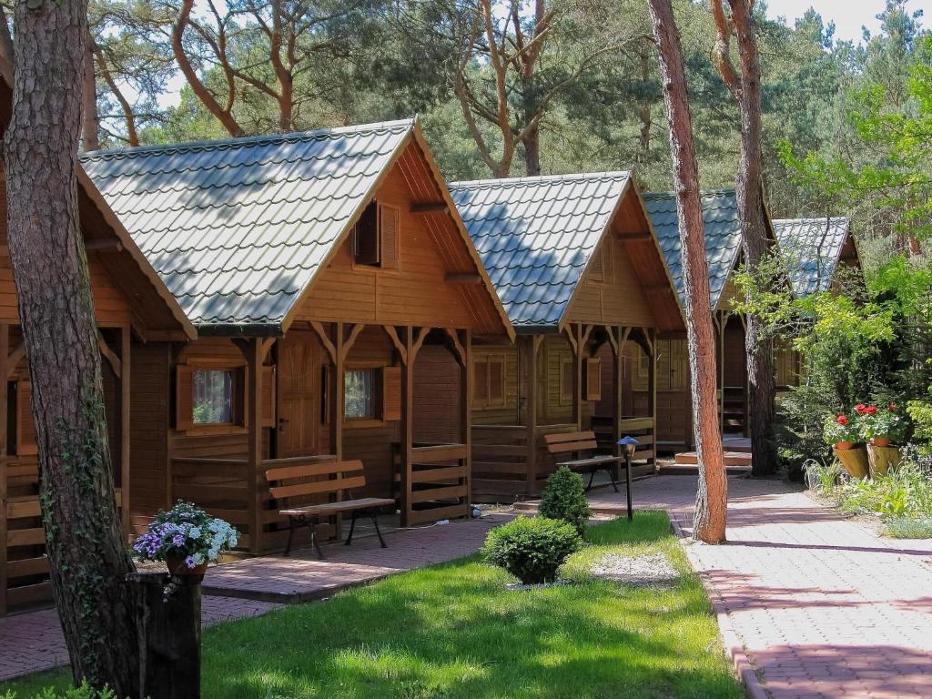 a log cabin with solar panels on its roof at Cozy holiday cottages close to the beach, azy in Łazy