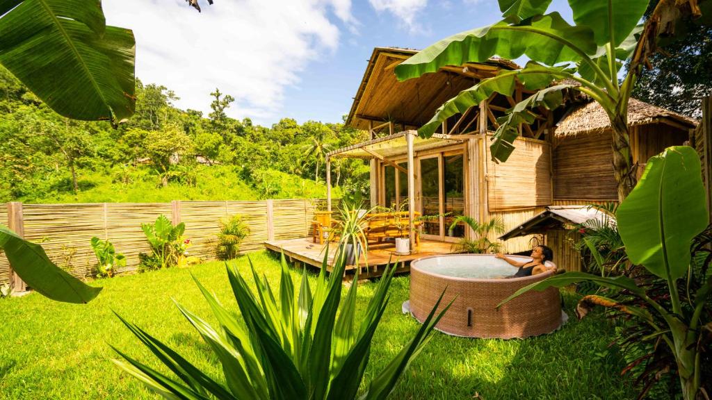 a woman sitting in a tub in a yard at Palayan Villa - Villa with views, garden and jacuzzi in El Nido