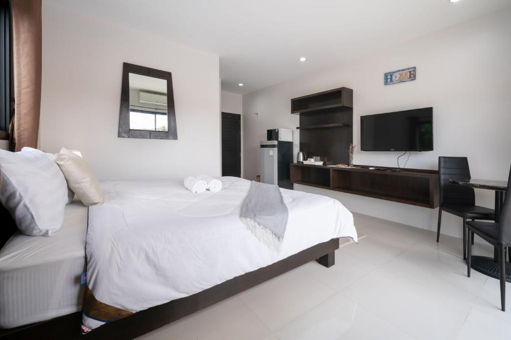 une chambre d'hôtel avec un lit et une télévision dans l'établissement SD Residence I Naiyang Beach I HKT Airport, à Ban Bo Han