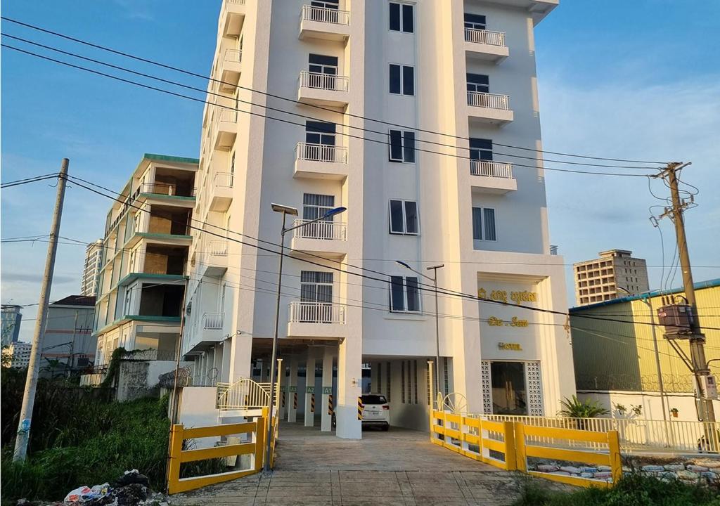 シアヌークビルにあるDa San Hotelの黄色い柵の高い建物