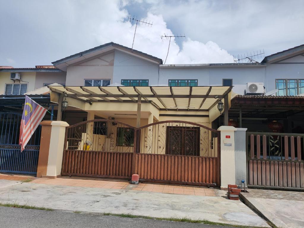 a house with a wooden gate and a fence at Kapar Nala 34A /3 Rooms/4-8 pax in Kapar