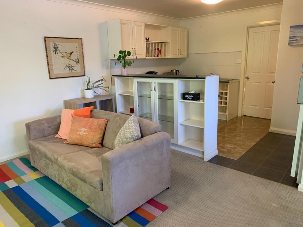 a living room with a couch and a kitchen at Very Comfortable Granny Flat in Yass