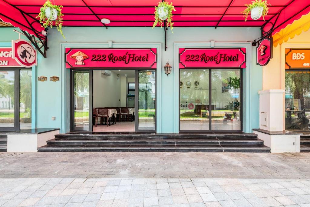 a store front with pink signs on the windows at 222 ROSÉ Hotel in Phú Quốc