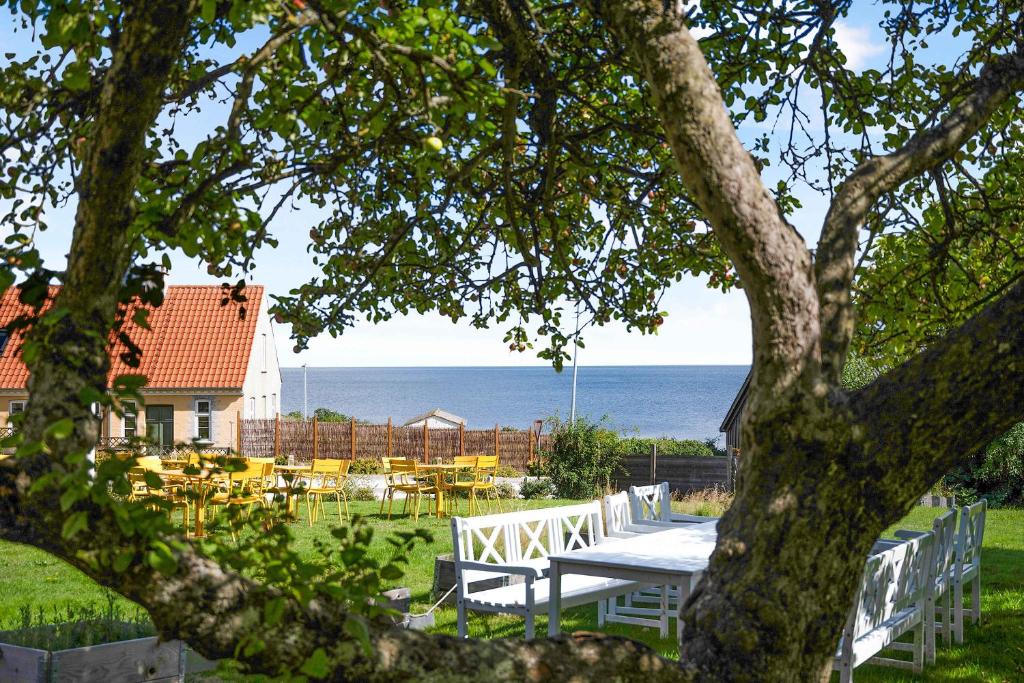 einen Picknicktisch im Garten mit Meerblick in der Unterkunft Summer Holiday Apartment At Beautiful Solgaarden in Svaneke