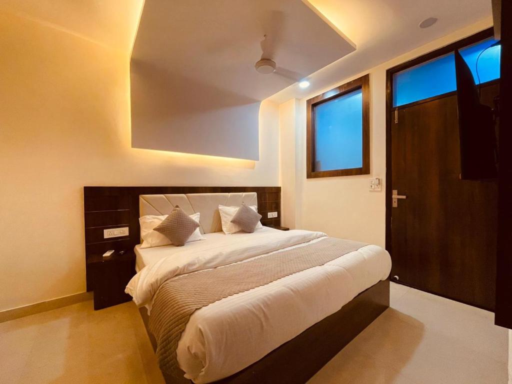 um quarto com uma cama grande e lençóis brancos em The White House Haridwar em Haridwar