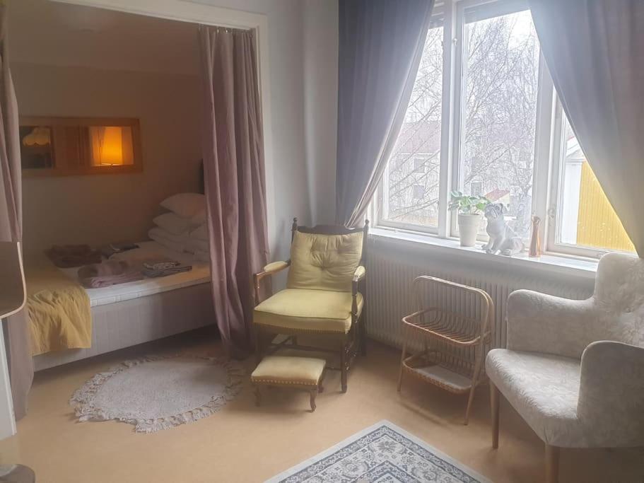 1 dormitorio con silla, cama y ventana en Central hel lägenhet. Nära till allt., en Umeå