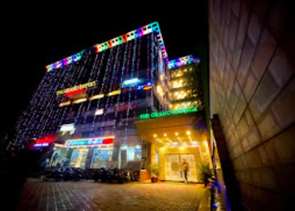 un edificio alto con luces encendidas por la noche en The Grand Empire Best 4 Star Luxury Hotel in Patna, en Patna