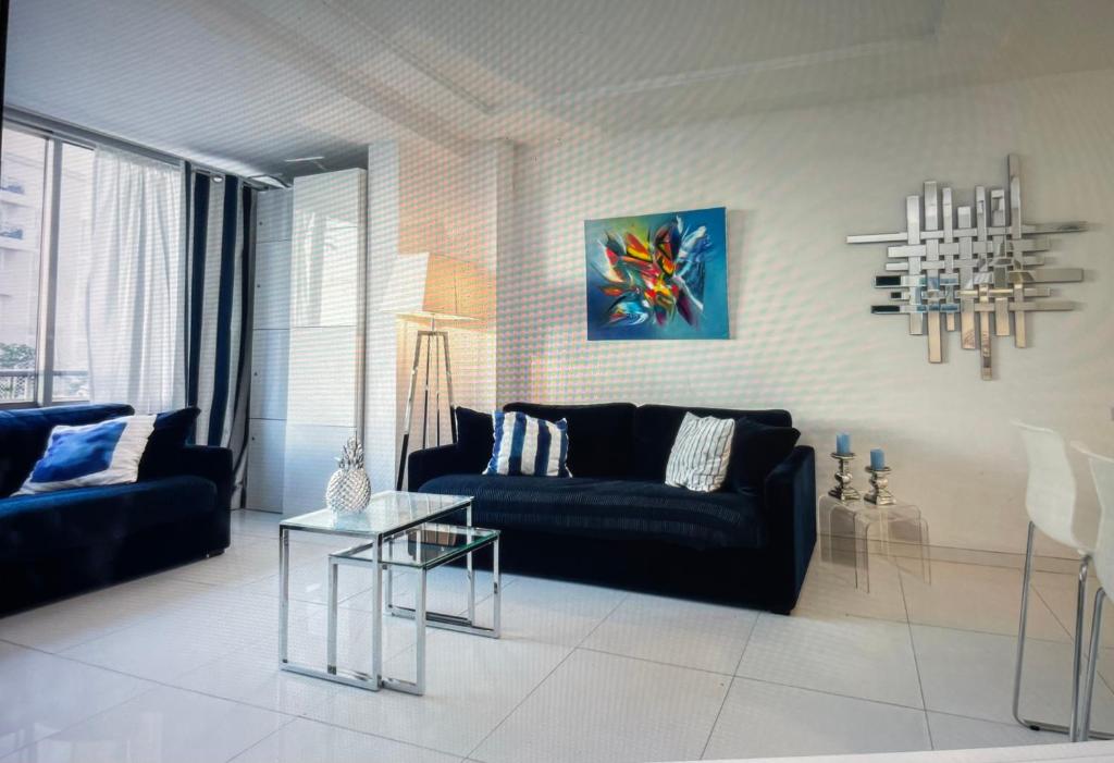 - un salon avec un canapé noir et une table en verre dans l'établissement 45 Croisette, à Cannes