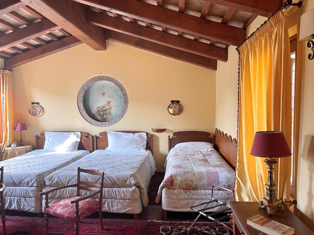 sypialnia z dwoma łóżkami i stołem z lampą w obiekcie B&B Casa Camilla w Padwie