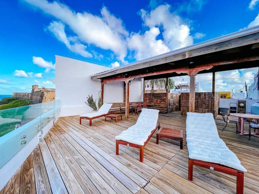 una terraza con bancos y mesas en la parte superior de un edificio en Hiddem Gem w/ Ocean View & Rooftop @ Old San Juan en San Juan