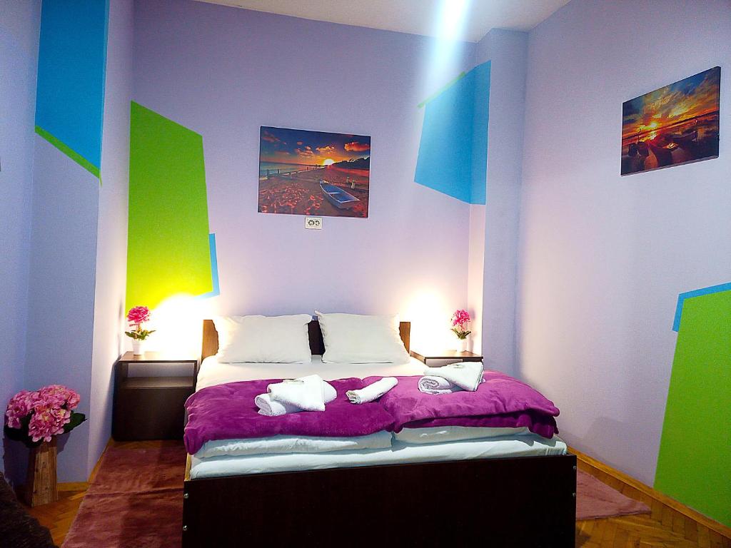 a bedroom with a bed with purple and green walls at "Maria Luisa" - Top center apartment in Sofia