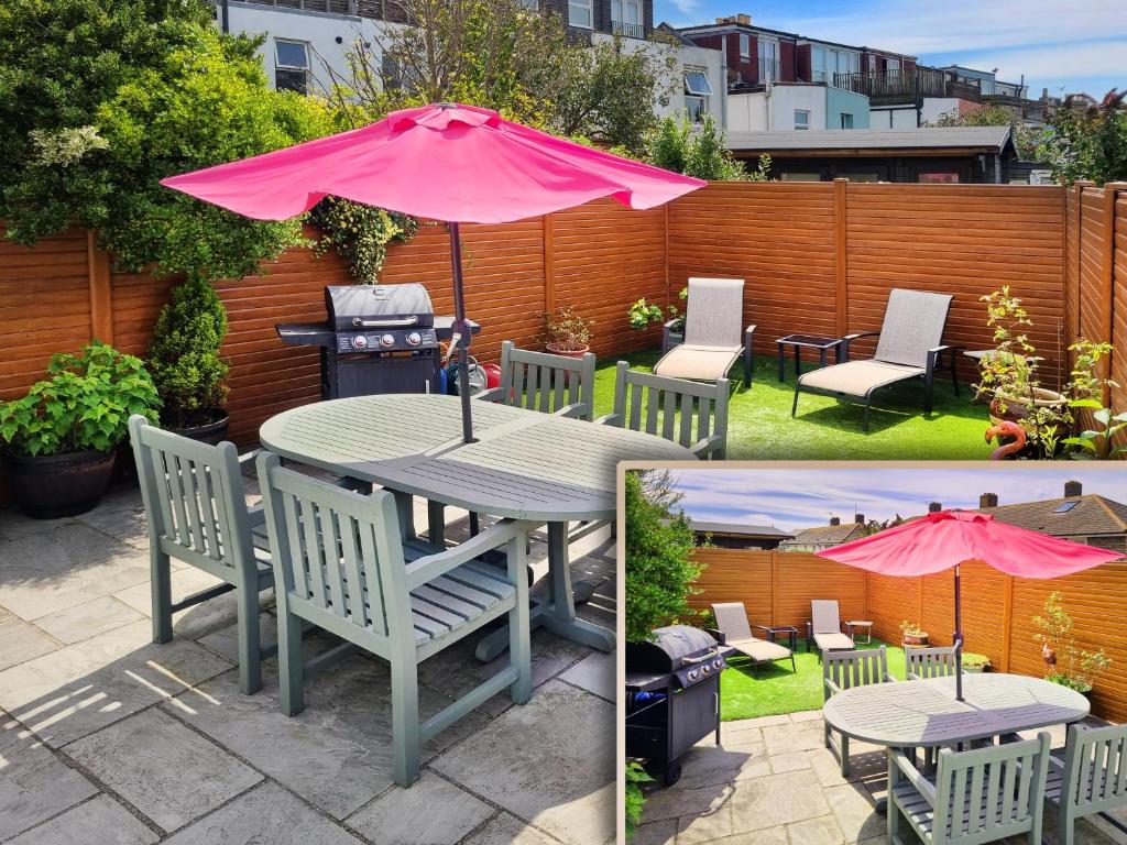 une terrasse avec une table, des chaises et un parasol rose dans l'établissement Sunny Queens Park Home - Garden & Private Parking, à Brighton et Hove