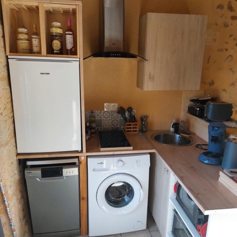 a kitchen with a washing machine and a washer at COCON in La Douze