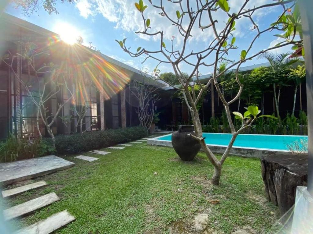 een tuin met een boom en een zwembad bij Apantree pool villa Than Ing Doi in Hang Dong