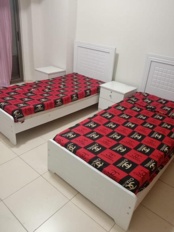 two beds sitting next to each other in a room at SHAFA Holiday Homes in Dubai