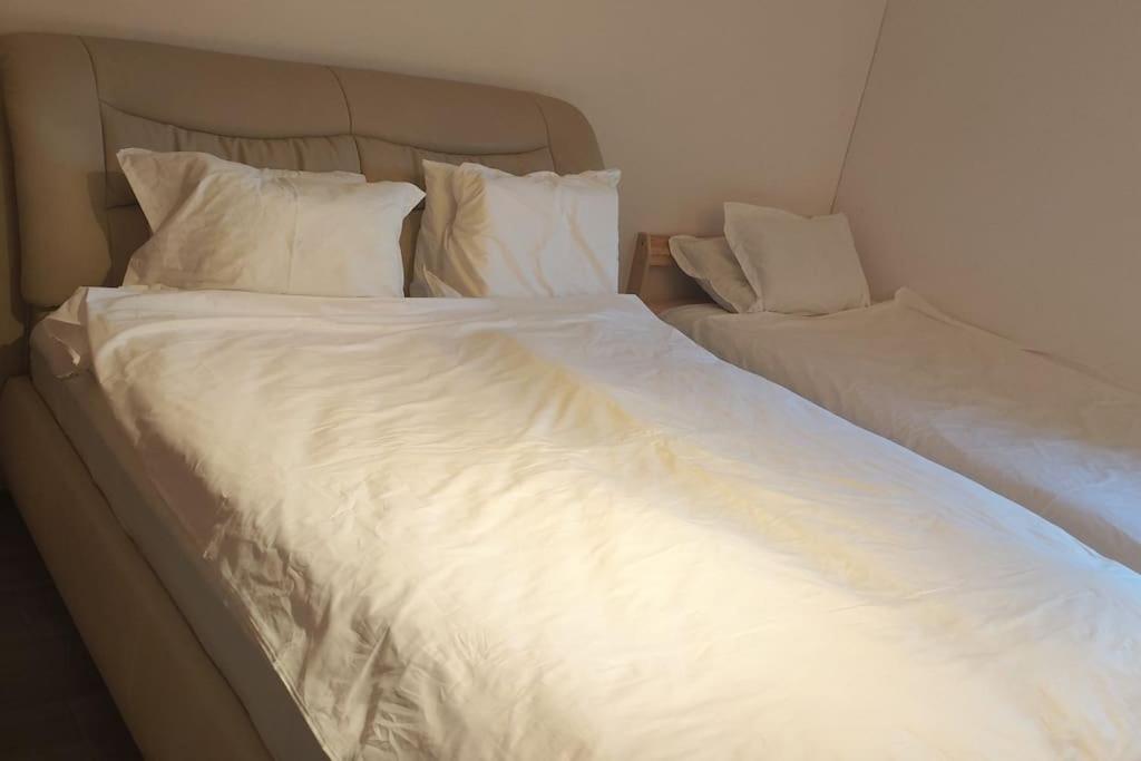 a large bed with white sheets and pillows at Ferienwohnung mit Garten in Vienna