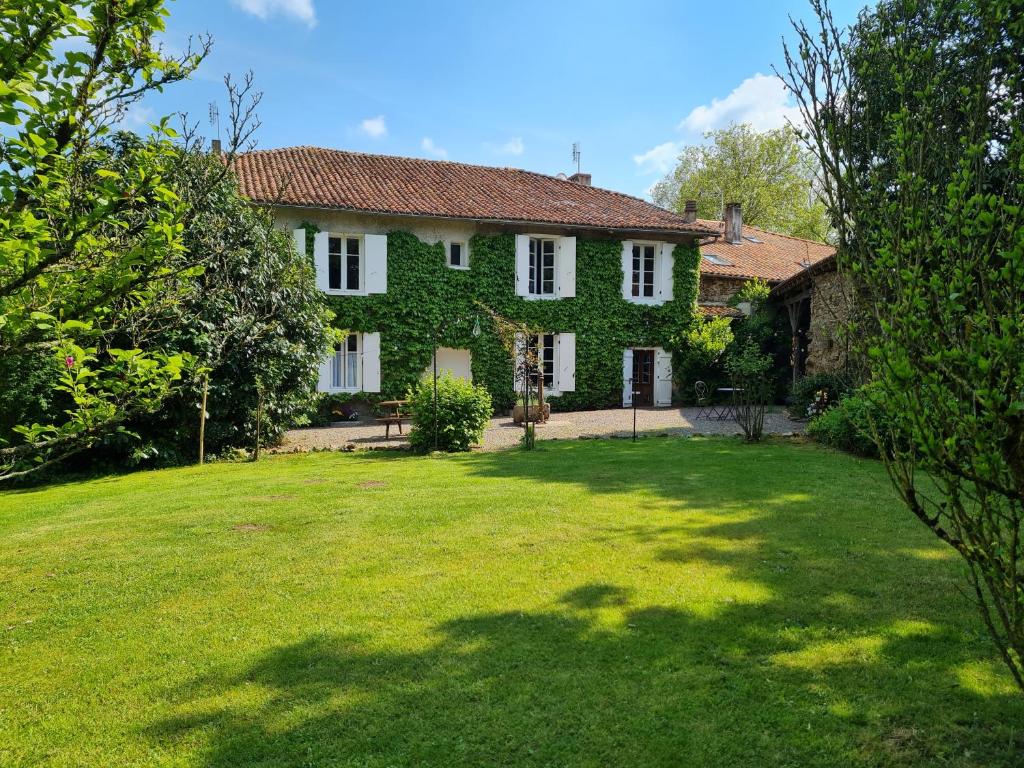 a house with a large yard with a grassy yard at Fleur de Lys in Ansac-sur-Vienne