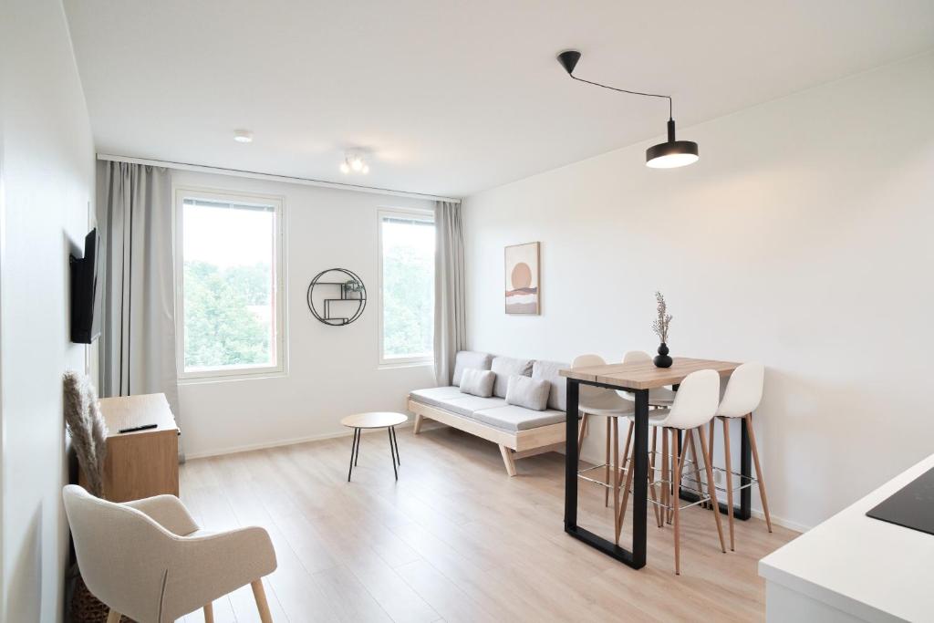 a white living room with a table and a couch at Norden Homes Turku Nordic Apartment with Free Parking in Turku